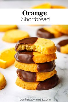 orange shortbread cookies stacked on top of each other with chocolate drizzled on them