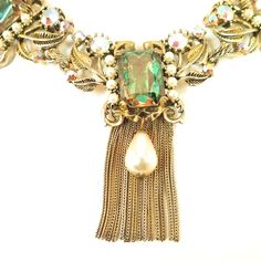 This is part of Chairish’s Costume Jewelry assortment.  Offered here is an Amerique Baroque-style gold-plated necklace and matching clip-back earrings from the 1950s. The design exemplifies classic Baroque characteristics, include flowing lines, floral motifs, and an obsession with symmetry. The central portion is comprised of three panels linked together, each in a mirror-image motif of curling ribbons and leaves. Each segment is centered with a large bi-color watermelon glass stone, flanked by Pearl Necklace Earrings, Baroque Style, Baroque Fashion, Accessories Jewelry Necklace, Mirror Image, Gold Plated Necklace, Floral Motifs, Vintage Costume Jewelry, Necklace Earring Set