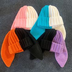 four knitted hats laying on top of each other