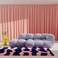 a living room with pink curtains and a blue couch in front of a colorful rug