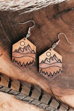 wooden earrings with mountains and sun on them