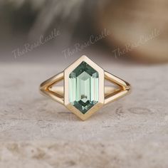 a green tourmaline ring sitting on top of a table