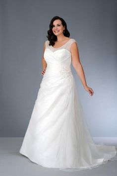 a woman in a white wedding dress posing for the camera