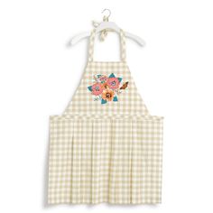 a white and yellow apron with flowers on the front, hanging from a hanger