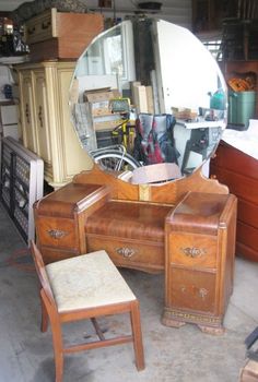 an antique vanity with mirror and stool in a garage