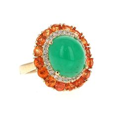 9.04 Carat Emerald Diamond and Orange Sapphire Cocktail Ring!  The most unique ring of all! A beautiful Cabochon Emerald sits in the center of the ring and is surrounded by a cluster of Orange Sapphires and Diamonds.  The carat weight of the stones are as follows:  Emerald = 6.55 carats (measurements of the Emerald are 10mm x 12mm) 16 Orange Sapphires = 2.20 carats 26 Round Cut Diamonds = 0.29 carats (Clarity: SI, Color: F)  The total carat weight of the ring is 9.04 carats.  The ring is set in Yellow Gold Multi-stone Cabochons Fine Jewelry, Yellow Gold Multi-stone Cabochons For Fine Jewelry, Luxury Multi-stone Oval Cabochons, Formal Multi-stone Oval Cabochon Gemstones, Exquisite Round Gemstones With Halo Setting, Dazzling Oval Multi-stone Gemstones, Oval Multi-stone Gemstones, Formal Cluster Jewelry With Gemstone Accents, Green Cluster Multi-stone Rings