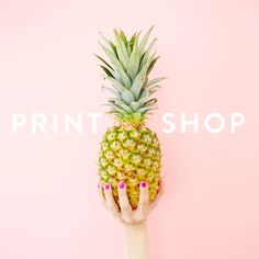 a woman's hand holding up a pineapple against a pink background with the words print shop