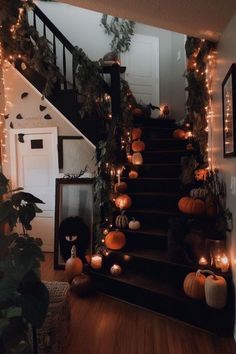 the stairs are decorated with pumpkins and greenery for halloween time, but it's not too scary