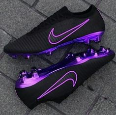 a pair of black and purple nike soccer shoes on the ground in front of a brick floor