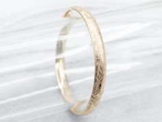 The details on this vintage 14-karat gold bangle are simply stunning! Intricate scrolling botanical designs are engraved in warm yellow gold, covering the entire bracelet. Beautiful on its own or layered with other bracelets this piece is perfect for day or evening wear.Metal: 14K Yellow GoldWidth: 6.3 mmInside Circumference: 6 1/2 InchesMarks: "JW 14K" Stamped on the inside band Classic Yellow Gold Bracelets With Engraving Option, Formal Bangle Bracelet With Engraving Option, Anniversary Yellow Gold Bracelet With Engraving Option, Heirloom Etched Bangle, Elegant Gold Bangle With Engraving Option, Gold Bangle Jewelry With Engraving Option, Classic Etched Bangle For Wedding, Elegant Engraved Bangle, Elegant Etched Yellow Gold Cuff Bracelet