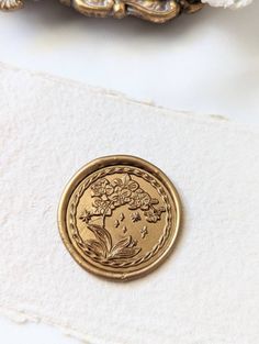 a close up of a gold coin on a white surface with other items in the background