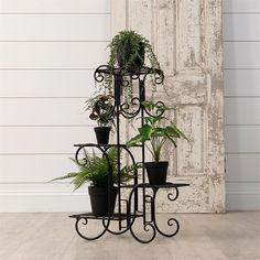 an iron plant stand with potted plants on it