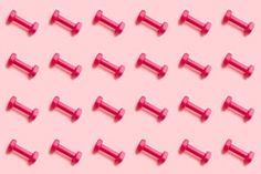 a pink background with several red plastic pegs