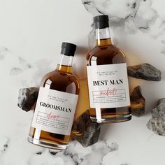 two bottles of grooms man whiskey sitting next to each other on a marble surface