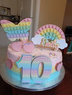 a colorful birthday cake with the number 10 on it's top and rainbow decorations