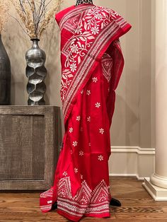 Elevate your ethnic elegance with our exquisite Red Kantha Stitch Saree crafted from luxurious Bangalore Silk, Silk Mark Certified. This saree is adorned with delicate white floral motifs, adding a touch of timeless charm to your wardrobe. Embrace the allure of tradition and sophistication as you drape yourself in this resplendent ensemble. Make a statement on any occasion with this beautifully handcrafted piece that captures the essence of grace and style. Occasion: Party, Festival, Wedding Fabric: Tassar Silk Certification: Silk Mark Work: Woven, Kantha Stitch, Hand-painted Fall / Pico:  Included Blouse Piece: Has matching blouse piece Shipping: Ships from the USA Made in India Please note that the actual color of the apparel in photos may vary slightly due to lighting and screen setting Kantha Stitch Saree, Stitch Saree, Flower Motifs, Red Saree, Kantha Stitch, Wedding Fabric, Party Festival, Festival Wedding, Red Silk