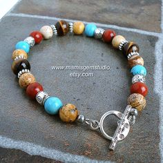 "This is a southwestern inspired men's bracelet that I handcrafted by combining natural semi-precious gemstone beads: Tiger Eye with beautiful golden brown luster, teal blue Magnesite (as known as Magnesite Turquoise), Red Jasper in rich brick red, and earthy looking Picture Jasper. I accentuated with silver-tone pewter beads and spacers to add a touch of tribal flavor, and finished off with a tribal style toggle clasp. A lobster claw clasp option is also available. All metal materials are lead- Southwestern Natural Stones Beaded Bracelet Gift, Southwestern Style Beaded Bracelets With Gemstone Beads, Southwestern Beaded Bracelets For Jewelry Making, Southwestern Style Adjustable Gemstone Beads Bracelets, Southwestern Gemstone Beads Bracelet For Healing, Southwestern Gemstone Beads Healing Bracelet, Southwestern Style Healing Gemstone Beads Bracelet, Southwestern Style Beaded Bracelets With Round Beads For Healing, Southwestern Style Healing Round Beaded Bracelets