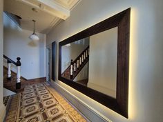 This extra-large wall mirror will suite either contemporary or traditional interior styles. The grand frame made in cherry and finished in dark oak stain oversized mirror is certainly a real showstopper. With engraved Greek key pattern, it gives this mirror an awe - inspiring finish. The rectangular frame dresses the wall, adding elegance and a sense of spaciousness Cleverly incorporated led lights add a warm and cosy glow to the frame and the hallway. Thick Framed Mirror, Hallway Mirror Entrance, Big Mirror Entryway, Frame Large Mirror, Mirror Behind Nightstand, Oversized Wall Mirror, Extra Large Wall Mirrors, Mirror Stairs, Extra Large Mirrors