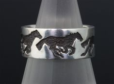 a silver ring with two horses on it