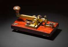 an old fashioned sewing machine sitting on top of a wooden stand with metal knobs