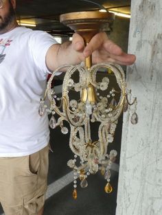 a man holding a chandelier in his hand