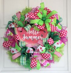 a wreath with the words hello summer written on it and green, pink, and white bows