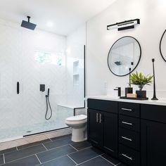 a bathroom with black cabinets and white walls