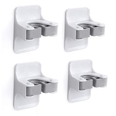 three white wall mounted soap dispensers on a white wall with four holders