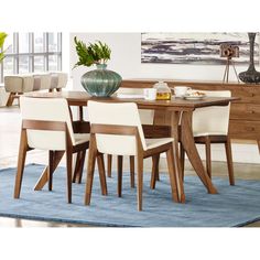 a dining room table with chairs and a vase