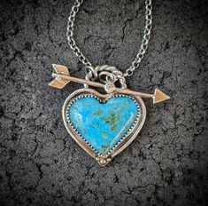 Genuine Kingman, Arizona turquoise heart is set in a handcrafted oxidized 925 sterling silver bezel with accents of 14k gold. Front closing arrow toggle closure features a Moissanite diamond for a touch of sparkle. Connects  to a 2.2mm medium weight and sturdy rolo chain.  ~Turquoise D 24mm x 28mm (Large size with inclusions of pyrite) ~Turquoise E 28mm x 34mm (Extra large size with tiny inclusions of pyrite) ~Natural untreated American mined stones ~Wrapped in black gift box ~Handmade in Tennes Heirloom Turquoise Jewelry Gift, Heirloom Turquoise Jewelry For Gift, Artisan Jewelry With Heart Charm As Gift, Artisan Jewelry With Heart Charm For Gift, Artisan Pendant Jewelry For Valentine's Day, Unique Handmade Heart Cut Jewelry, Turquoise Jewelry With Heart Charm For Anniversary, Turquoise Heart Charm Jewelry For Anniversary, Unique Hand Forged Heart Pendant Jewelry