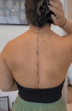 the back of a woman's neck with vines on it