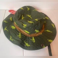 a green hat with yellow dinosaurs on it