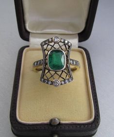 Art Deco emerald ring with diamonds, made of 14K gold and silver. With a Hungarian 14K hallmark that was used after 2016. The top part is made of silver. The head part of the ring is 0.796 inches (20 mm) long. Gemstone: one piece of emerald, 1.54 carat, its size is: 0.24 inches * 0.31 inches (6.1 mm * 7.8 mm) The emerald has inclusions which unfortunately affects the surface of the stone as well. I tried to make photos of that. Additional gemstone details: 20 single cut diamonds Carat weight: 0. Art Deco Emerald Ring With Rose Cut Diamonds, Art Deco Green Emerald Ring With Rose Cut Diamonds, Art Deco Emerald Diamond Ring With Accents, Elegant 14k Stamped Emerald Ring, Art Deco Emerald Ring With 17 Jewels For Anniversary, Art Deco Emerald Ring With Diamond As Gift, Art Deco Emerald Ring With Diamond For Gift, Antique Green Emerald Cut Emerald Ring, Antique Green Emerald Cut Ring