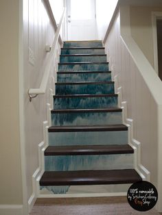 a set of stairs painted with blue and white watercolors in a home hallway