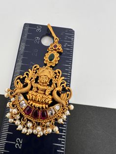 Matte Kempu Goddess Lakshmi Mang TikaColor : GoldenSize : Length : Approx 3.25 inchesStones : Red Green Stone CZ Pearls Antique Necklace Victorian, Mang Tika, Mang Tikka, Real Pearl Necklace, Ethnic Necklaces, Traditional Earrings, Goddess Lakshmi, Kundan Necklaces, Oxidised Jewellery