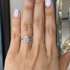 a woman's hand with a diamond ring on it