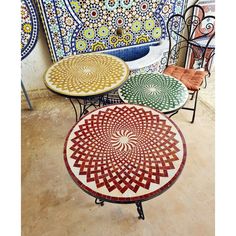 three tables and two chairs with designs on them