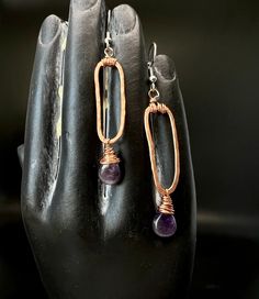 Rustic Amethyst Paper Clip Drop Earrings   ✨ Choose your preferred Earwires ✨ Handmade, Forged, and Hammered Copper ✨ Faceted Authentic Amethyst 💫 Handcrafted using natural materials, these earrings feature the beautiful polished Amethyst gemstone -the February Birthstone. The hammered texture and earthy tones allow the delicate purple shades to pop-making these a tasteful boho choice.   All items are shipped ready to gift or enjoyed as a treat. Feel free to reach out if you have any questions.  See more styles here! https://www.etsy.com/shop/BinkStudio?ref=profile_header&section_id=35372010 Everyday Purple Amethyst Earrings, Amethyst Wire Wrapped Drop Earrings, Handmade Amethyst Drop Earrings, Wire Wrapped Amethyst Drop Earrings, Handmade Amethyst Teardrop Crystal Earrings, Purple Teardrop Metal Jewelry, Adjustable Purple Earrings With Natural Stones, Spiritual Amethyst Drop Earrings, Everyday Purple Jewelry With Ear Wire