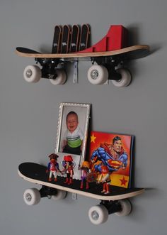 two skateboards mounted to the side of a wall with pictures and toys on them