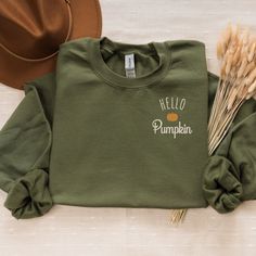 Welcome the cozy vibes of fall with our "Hello Pumpkin" embroidered crewneck! This comfy sweatshirt is made from a soft 50/50 cotton polyester blend, offering both warmth and durability. Whether you're sipping on a pumpkin spice latte or enjoying a crisp autumn walk, this crewneck is the perfect addition to your fall wardrobe. Product Details:Material: Cozy 50/50 cotton polyester blend for a soft, comfortable feelDesign: Fall-themed "Hello Pumpkin" design featuring a charming pumpkin accent embroidered on the left chestFit: Unisex sizing from S to 2XL, offering a relaxed fit that's perfect for layeringColors Available: Ash, Black, Maroon, Military Green, Navy, Sand, Forest Green, Sport Grey, WhiteCare Instructions: Machine wash cold, tumble dry low for best results Please Note: Colors may Green Cotton Sweater For Fall, Green Fall Sweater With Embroidered Logo, Fall Green Sweater With Embroidered Logo, Green Sweater With Embroidered Logo For Fall, Green Embroidered Logo Sweater For Fall, Green Sweatshirt With Embroidered Logo For Fall, Fall Sweatshirt With Embroidered Logo For Loungewear, Fall Sweater With Embroidered Logo For Loungewear, Green Comfortable Fit Sweatshirt For Fall