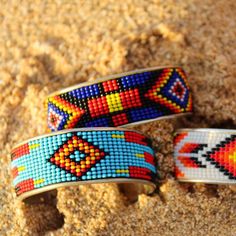 A metallic cuff with a beaded design in brilliant colors calling out a true southwest feel. Band is 2 3/8 inches in diameter, Cuff is approximately 1 inch wide. Blue Bracelet, Brilliant Colors, Cobalt Blue, Blue Orange, Cuff Bracelet, Embroidered Friendship Bracelet, Cuff, Beaded Bracelets, Orange