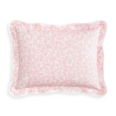 a pink and white pillow with speckles on the front, sitting against a white background