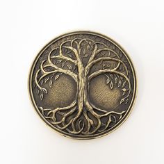 a metal button with a tree design on it