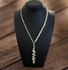 This lariat-style necklace combines the timeless elegance of pearls with the sleekness of sterling silver chain. It features a descending line of lustrous pearls that dangles gracefully from a silver curve, offering a sophisticated and modern twist on classic pearl jewelry. Perfect for both day and evening wear, it adds a refined touch to any ensemble. Classic Pearl Jewelry, Lariat Style Necklace, Fredericksburg Va, Style Necklace, Sterling Silver Chain, Pearl Jewelry, Sterling Silver Chains, Evening Wear, Silver Pendant