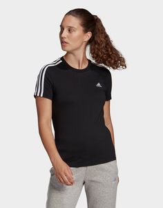 Refresh your off-duty rotation with this women’s Essentials 3-Stripes T-Shirt from adidas. In a Black colourway, this slim-fit tee is cut from soft cotton fabric for lasting comfort. It features a crew neckline and short sleeves for a classic cut and is signed off with the 3-Stripes to the shoulders and the Badge of Sport logo to the chest. Machine washable. Plastic Waste, Adidas Tops, Tennis Skirt, Striped Tee, Black Adidas, Workout Tee, Workout Leggings, Cotton Shorts, Classic Looks