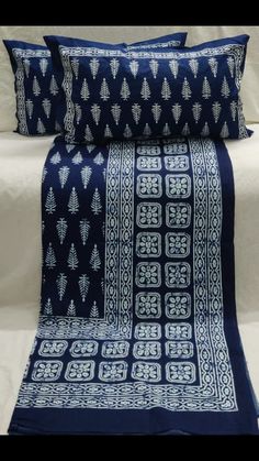 two blue and white bedspreads on top of each other with decorative designs