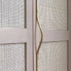 a close up view of a door handle on a white and beige door with mesh coverings