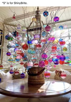 a vase filled with lots of colorful glass balls sitting on top of a wooden table