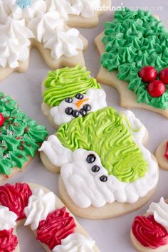 decorated cookies with frosting and icing are arranged on a white surface, including snowmen