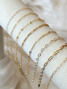 Please review the bracelet sizing guide below for the perfect fit! These dainty 14k Gold Filled Chain bracelets make a lovely addition to any bracelet stack! Simple and classic, these layering bracelets are made to compliment any outfit and are made with with sensitive skin safe, water safe, and long lasting materials! Details: * 14K Gold Filled chain and accents (USA 14/20 genuine Gold Filled) * Choose your chain style: Flat Cable Chain - 1.7x2mm Sequin Chain - 2.5x5mm  Beaded Satellite Chain - 2mm ball Figaro Chain - 2mm Paperclip Chain 1 - 3x6mm Paperclip Chain 2 - 2x5mm Heart Chain - 3.3mm (12K Gold Filled) Long Short Chain - 2mm * Choose your length (every bracelet has a .5" extender chain for adjustable sizing.) Bracelet Sizing Guide: 5-6.5 inches = xtra small 6.5-7 inches = small 7- Adjustable Delicate Chain Charm Bracelet, Gold Delicate Adjustable Paperclip Bracelet, Dainty Adjustable Chain Bracelet, Dainty Adjustable Paperclip Bracelet With Delicate Chain, Dainty Adjustable Paperclip Bracelet, Dainty Adjustable Gold Bracelet, Gold Minimalist Hypoallergenic Heart Bracelet, Minimalist Gold Hypoallergenic Heart Bracelet, Dainty Hypoallergenic Charm Bracelet